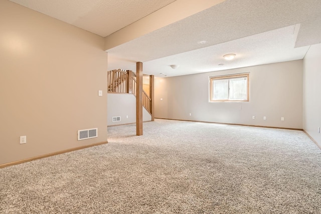 basement featuring carpet floors, stairway, baseboards, and a textured ceiling