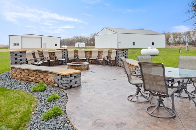 6435 172nd Ave SE, Colfax, ND 58018 - view of patio / terrace featuring an outbuilding, a fire pit, and outdoor dining area