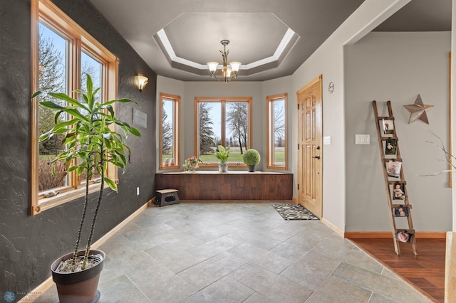 6435 172nd Ave SE, Colfax, ND 58018 - foyer entrance with stone finish flooring, baseboards, a chandelier, and a raised ceiling