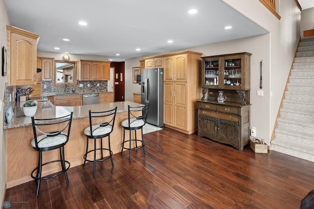6435 172nd Ave SE, Colfax, ND 58018 - kitchen featuring appliances with stainless steel finishes, dark wood finished floors, a peninsula, recessed lighting, and decorative backsplash
