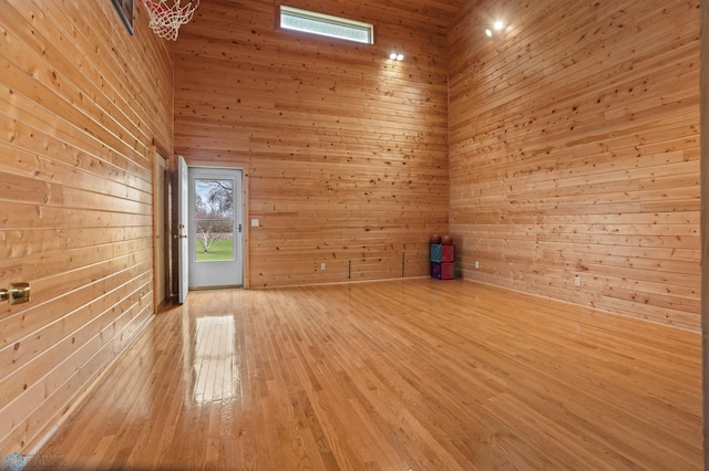 6435 172nd Ave SE, Colfax, ND 58018 - empty room featuring wooden walls, light wood-type flooring, and a towering ceiling
