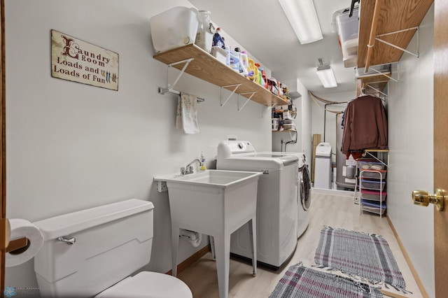 6435 172nd Ave SE, Colfax, ND 58018 - clothes washing area featuring light wood-style floors, washer and clothes dryer, and baseboards