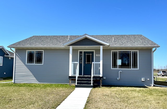 view of front of home featuring roof with shingles and a front lawn