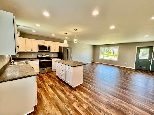 kitchen featuring dark countertops, stainless steel appliances, recessed lighting, and a sink