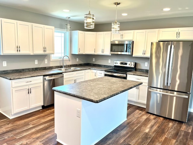 kitchen featuring a sink, stainless steel appliances, recessed lighting, white cabinets, and dark countertops