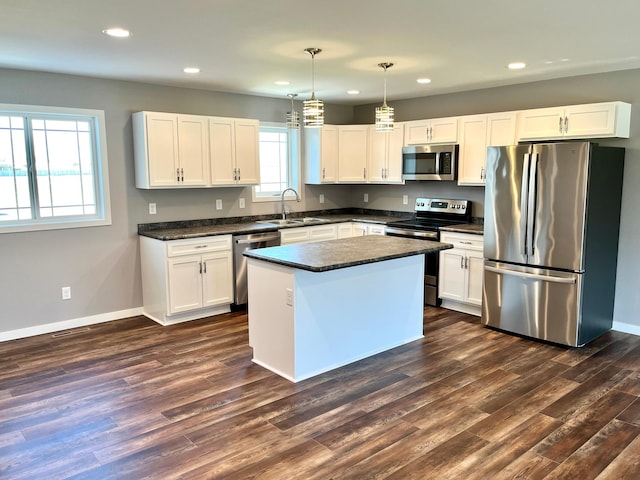 kitchen featuring recessed lighting, a sink, dark wood-type flooring, dark countertops, and stainless steel appliances