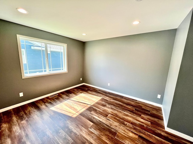 empty room featuring recessed lighting, baseboards, and wood finished floors