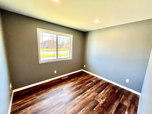 spare room featuring visible vents, dark wood-style flooring, baseboards, and recessed lighting