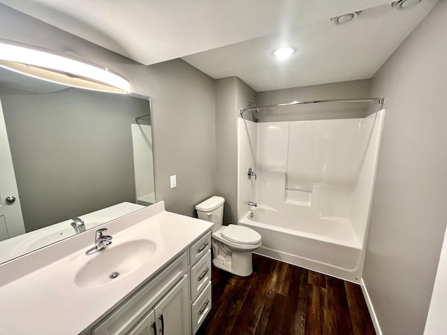 bathroom with vanity, toilet, wood finished floors, and shower / bathing tub combination