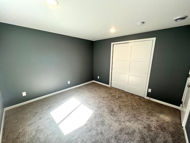 unfurnished bedroom featuring carpet, baseboards, a closet, and recessed lighting