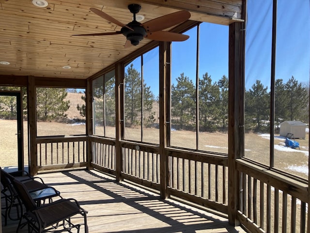 unfurnished sunroom with ceiling fan
