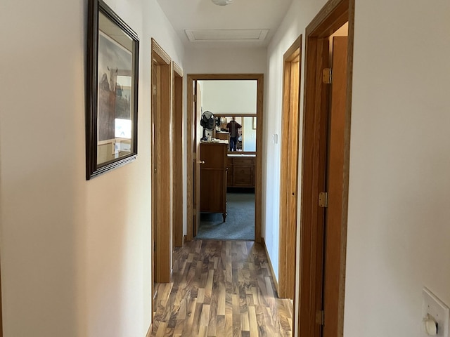 hallway with wood finished floors and attic access