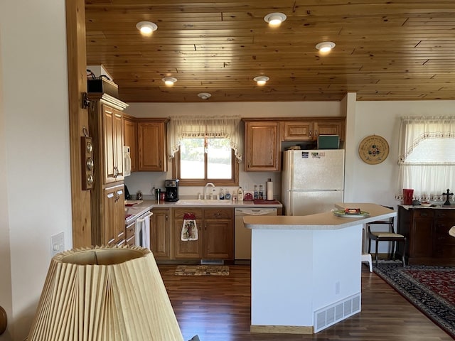 kitchen with visible vents, white appliances, dark wood-type flooring, wooden ceiling, and a sink