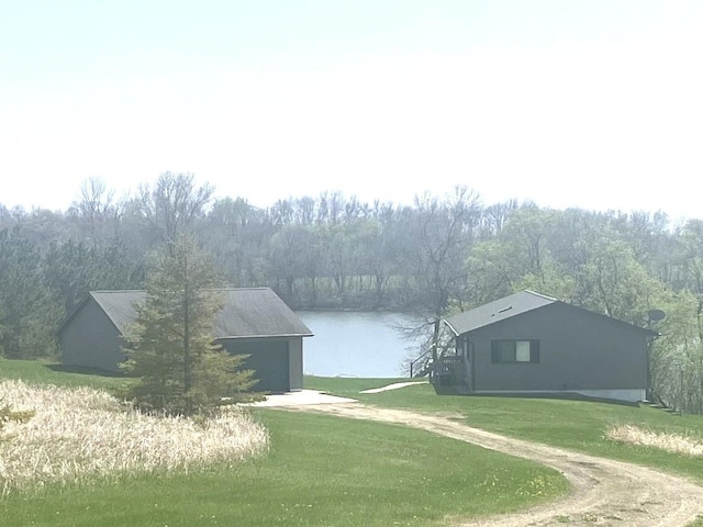 27588 226th St, Underwood, MN 56586 - view of green lawn with a water view, a garage, and driveway