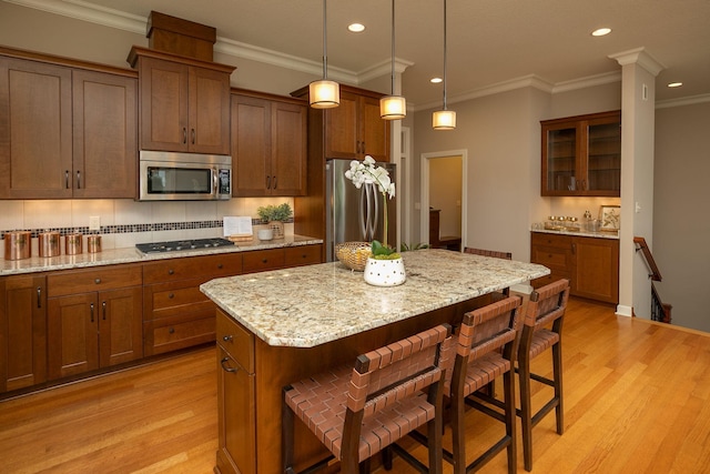 4051 Autumn Lake Ct SW, Rochester, MN 55902 - kitchen featuring stainless steel appliances, light wood-style flooring, a breakfast bar area, ornamental molding, and glass insert cabinets