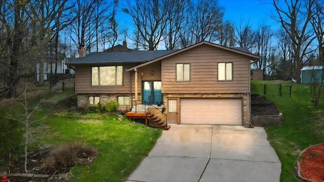 bi-level home with fence, driveway, a garage, a front lawn, and a chimney