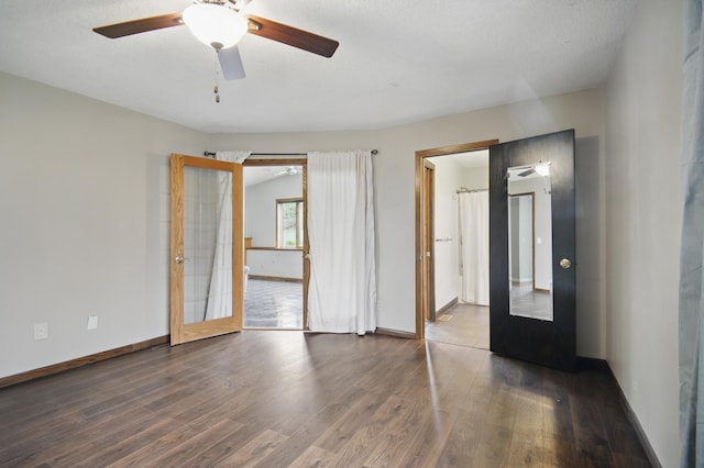 unfurnished bedroom with wood finished floors, baseboards, and a ceiling fan