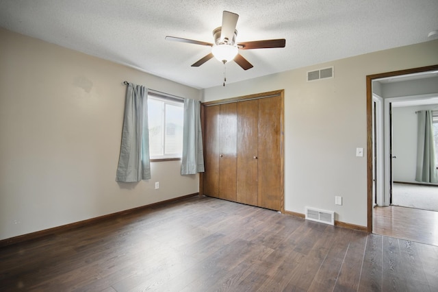 unfurnished bedroom featuring visible vents, wood finished floors, and baseboards