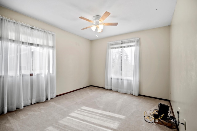 empty room featuring carpet, baseboards, and a ceiling fan