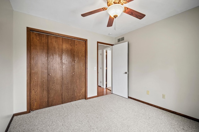 unfurnished bedroom with carpet flooring, baseboards, a closet, and ceiling fan
