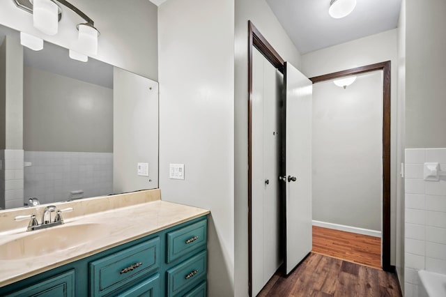 bathroom featuring vanity, a tub to relax in, and wood finished floors