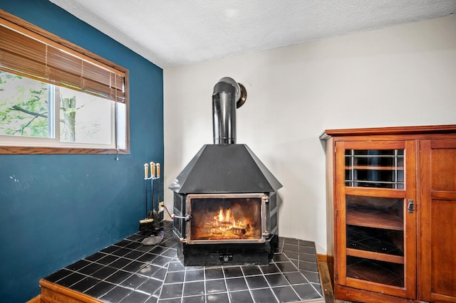 interior details with a wood stove and a textured ceiling
