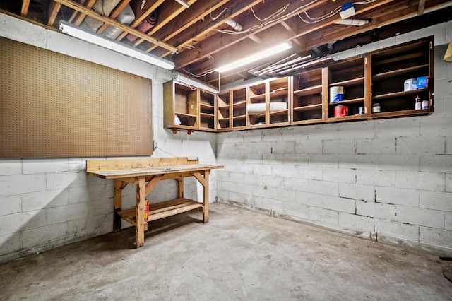 unfinished basement featuring a workshop area