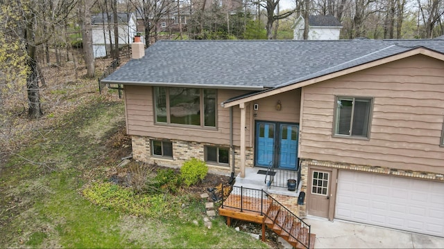 view of front of house with a chimney, a shingled roof, and an attached garage