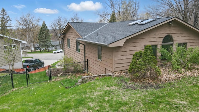 view of property exterior with roof with shingles and a gate