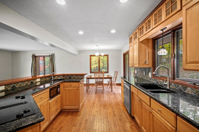 kitchen featuring black appliances, a sink, recessed lighting, pendant lighting, and light wood finished floors