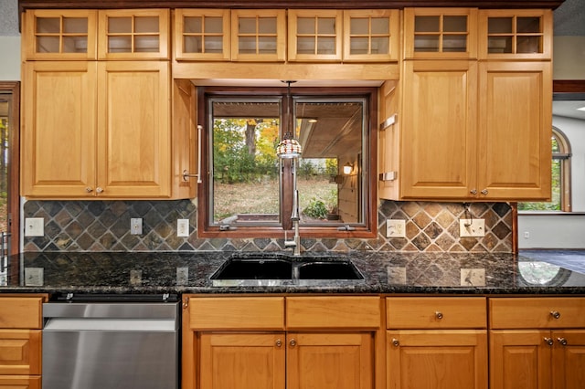 kitchen featuring stainless steel dishwasher, tasteful backsplash, glass insert cabinets, and dark stone counters