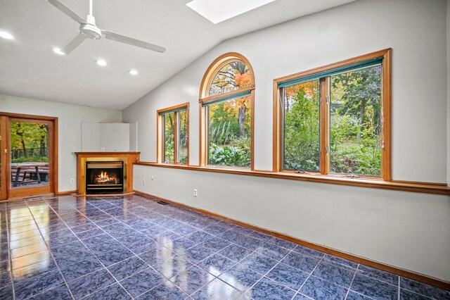 unfurnished living room featuring lofted ceiling, a skylight, ceiling fan, recessed lighting, and baseboards