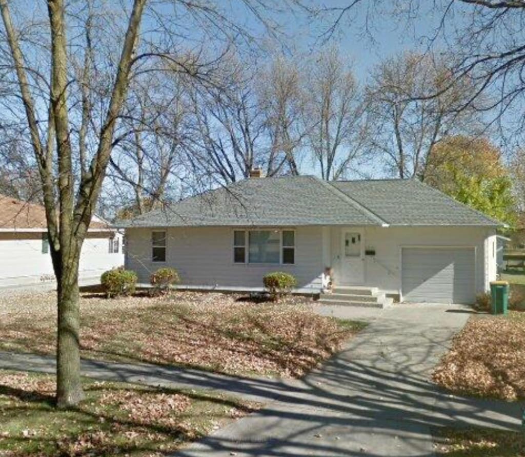 ranch-style home with a garage, driveway, and a chimney
