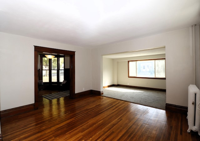 238 Lincoln St, Mankato, MN 56001 - spare room with baseboards, radiator heating unit, and wood finished floors