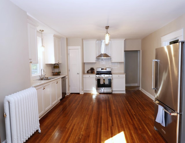 238 Lincoln St, Mankato, MN 56001 - kitchen featuring a sink, light countertops, radiator heating unit, wall chimney exhaust hood, and stainless steel appliances