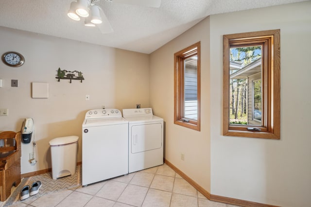 laundry area featuring washing machine and dryer, a ceiling fan, baseboards, light tile patterned floors, and a textured ceiling