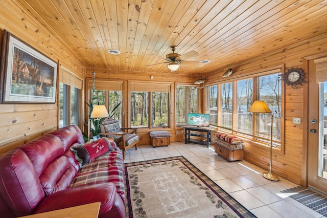 living room with light tile patterned flooring, wooden walls, a ceiling fan, and wood ceiling