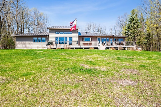 30501 336th Ln, Aitkin, MN 56431 - back of property with a wooden deck, a chimney, a lawn, and metal roof