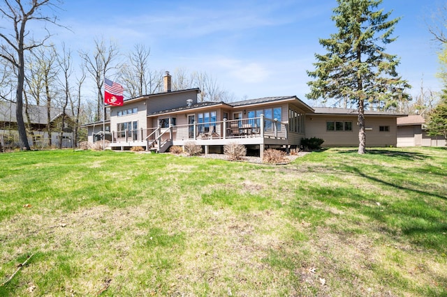 30501 336th Ln, Aitkin, MN 56431 - back of house featuring a chimney, a deck, and a lawn