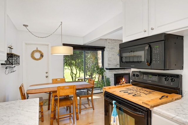 4508 Cedar Lake Rd S Unit 2, Saint Louis Park, MN 55416 - kitchen featuring white cabinetry, light stone countertops, black appliances, and a fireplace