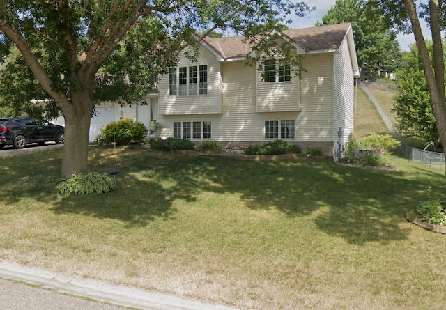 view of front of property with fence, a shingled roof, and a front lawn