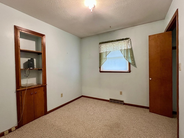 1207 3rd Ave S, Wheaton, MN 56296 - unfurnished bedroom featuring carpet flooring, a textured ceiling, visible vents, and baseboards