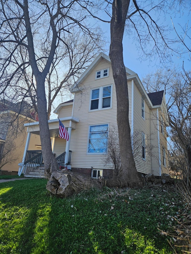 rear view of property with a yard and covered porch