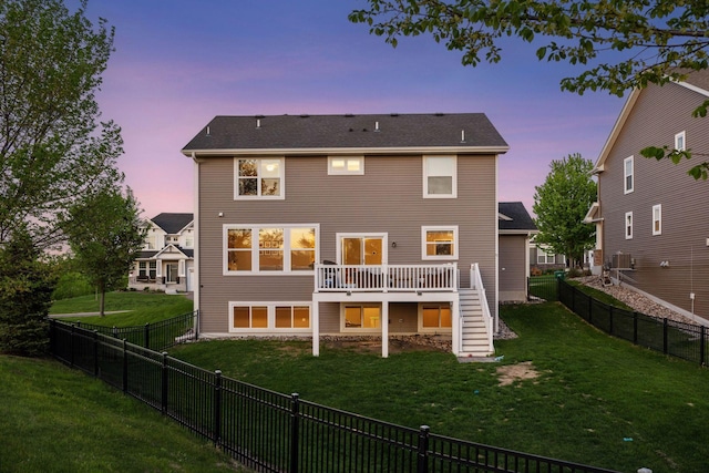 back of property at dusk featuring stairway and a deck
