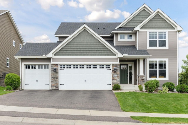 6573 Bridle Path, Corcoran, MN 55340 - craftsman house with asphalt driveway, an attached garage, a front lawn, stone siding, and roof with shingles