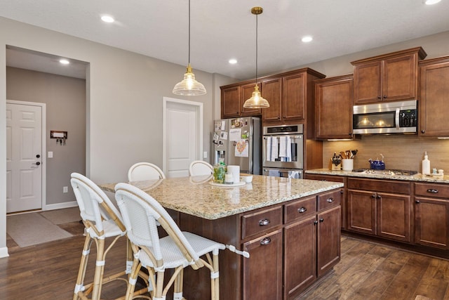 6573 Bridle Path, Corcoran, MN 55340 - kitchen featuring stainless steel appliances, a center island, a breakfast bar, dark wood-style flooring, and recessed lighting