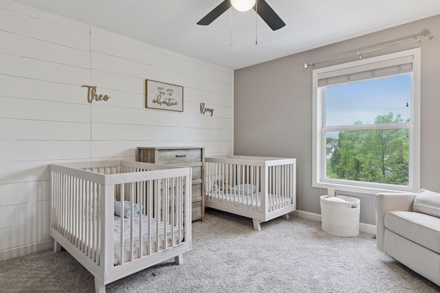 6573 Bridle Path, Corcoran, MN 55340 - bedroom with carpet flooring, a ceiling fan, a nursery area, and wood walls