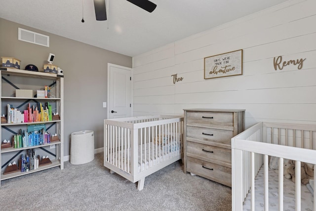 6573 Bridle Path, Corcoran, MN 55340 - bedroom with carpet floors, wooden walls, a crib, and a ceiling fan