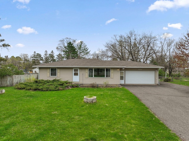 ranch-style house with a garage, fence, a front yard, and aphalt driveway