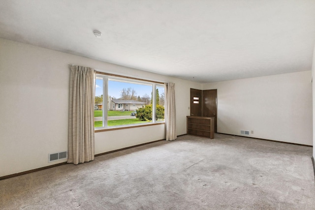 empty room featuring carpet flooring, baseboards, and visible vents
